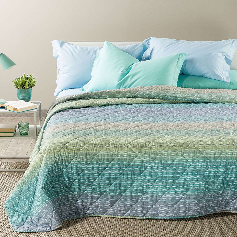 Trapuntino Caleffi Iride in morbida microfibra. Disponibile nella misura per letto singolo, piazza e mezza e matrimoniale. Trapunta primaverile dalla vivace fantasia geometrica con effetto degradè, colore laguna (verde,azzurro)