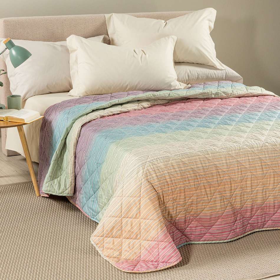 Trapuntino Caleffi Iride in morbida microfibra. Disponibile nella misura per letto singolo, piazza e mezza e matrimoniale. Trapunta primaverile dalla vivace fantasia geometrica con effetto degradè multicolor (arancio, verde,azzurro,rosa).