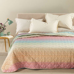 Trapuntino Caleffi Iride in morbida microfibra. Disponibile nella misura per letto singolo, piazza e mezza e matrimoniale. Trapunta primaverile dalla vivace fantasia geometrica con effetto degradè multicolor (arancio, verde,azzurro,rosa)