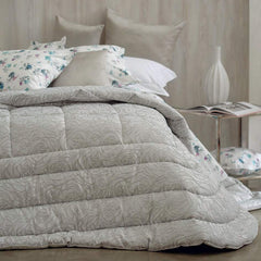 Trapunta invernale matrimoniale Dalida di Blumarine, in elegante raso jacquard. Il piumone Dalida presenta un'elegante fantasia floreale tinta in filo, con logo Blumarine in cristalli. Colore seppia beige