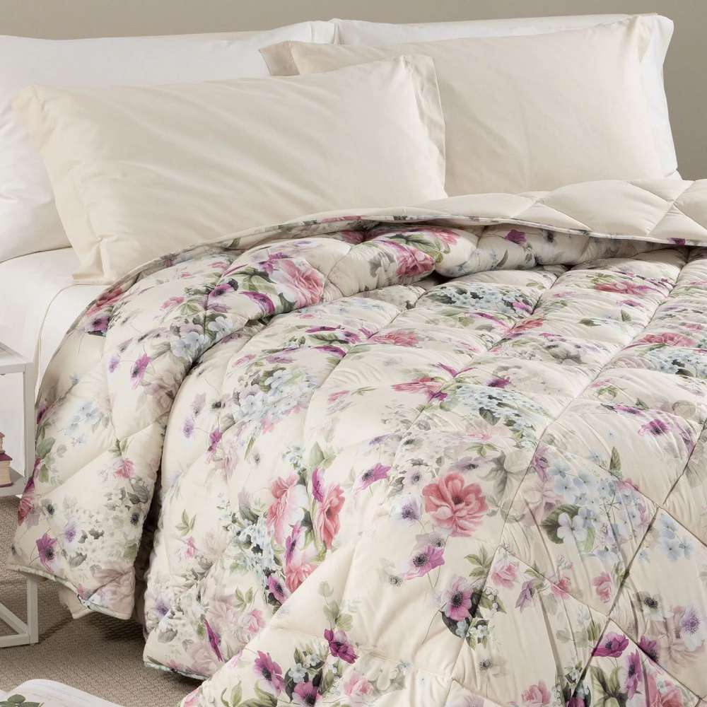Trapunta invernale Caleffi Damasco in microfibra. Disponibile nella misura per letto singolo, piazza e mezza e matrimoniale. Romantica fantasia floreale con fiori bianchi, rosa e glicine su fondo beige chiaro.
