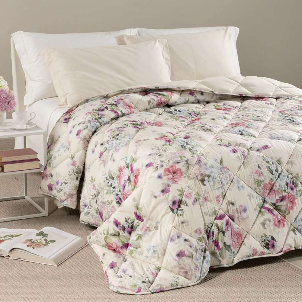 Trapunta invernale Caleffi Damasco in microfibra. Disponibile nella misura per letto singolo, piazza e mezza e matrimoniale. Romantica fantasia floreale con fiori bianchi, rosa e glicine su fondo beige chiaro.