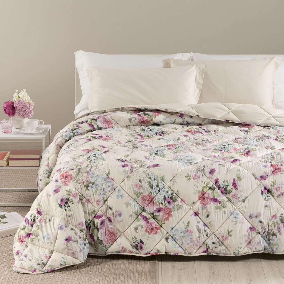 Trapunta invernale Caleffi Damasco in microfibra. Disponibile nella misura per letto singolo, piazza e mezza e matrimoniale. Romantica fantasia floreale con fiori bianchi, rosa e glicine su fondo beige chiaro.