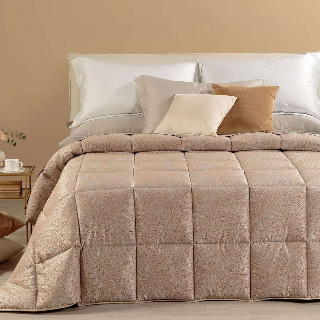 Trapunta invernale matrimoniale Caleffi Dorata, in prezioso raso jacquard.Il piumone Dorata è caratterizzato da una fantasia tono su tono, nella variante di colore ambra.