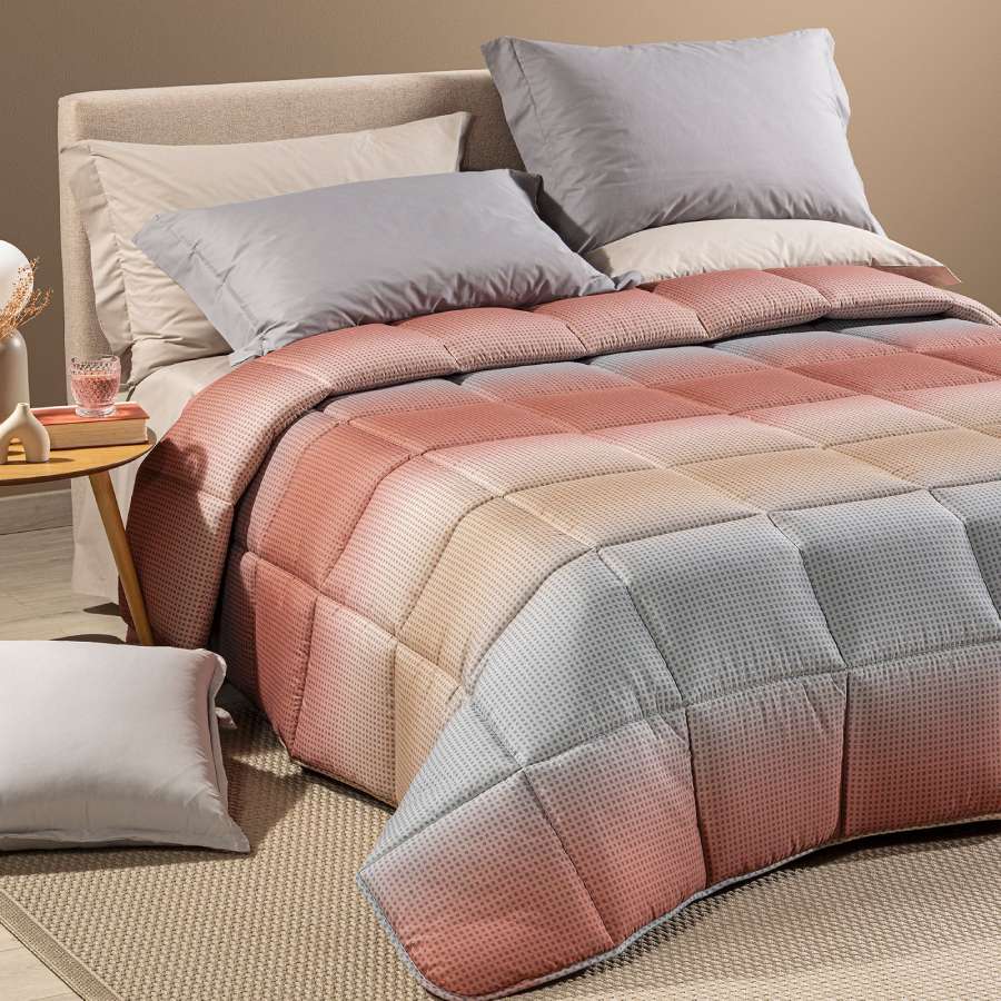 Trapunta invernale Caleffi Larry. Piumone con fantasia geometrica degradè grigio e corallo.