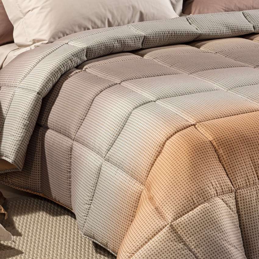 Trapunta invernale Caleffi Larry. Piumone con fantasia geometrica degradè grigio e gold.