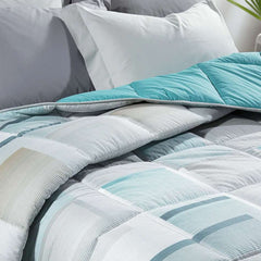 Trapunta invernale Caleffi Sidney in puro cotone. Disponibile nella misura per letto singolo, piazza e mezza e matrimoniale.Fantasia geometrica dallo stile moderno, colore grigio azzurro.