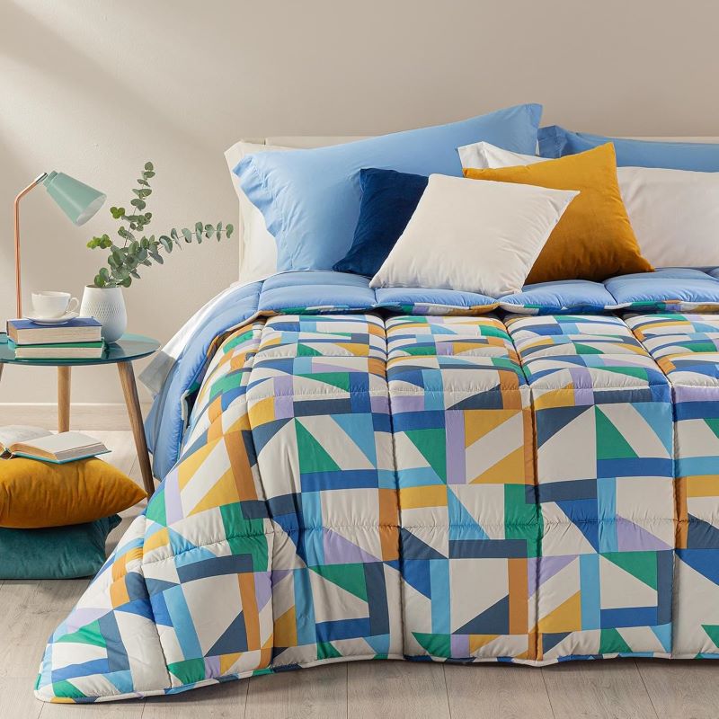 Trapunta invernale Caleffi Tuxedo in microfibra. Disponibile nella misura per letto singolo, piazza e mezza e matrimoniale. Fantasia allegra e moderna con forme geometriche colorate, variante bluette con elementi blu, verdi e senape.