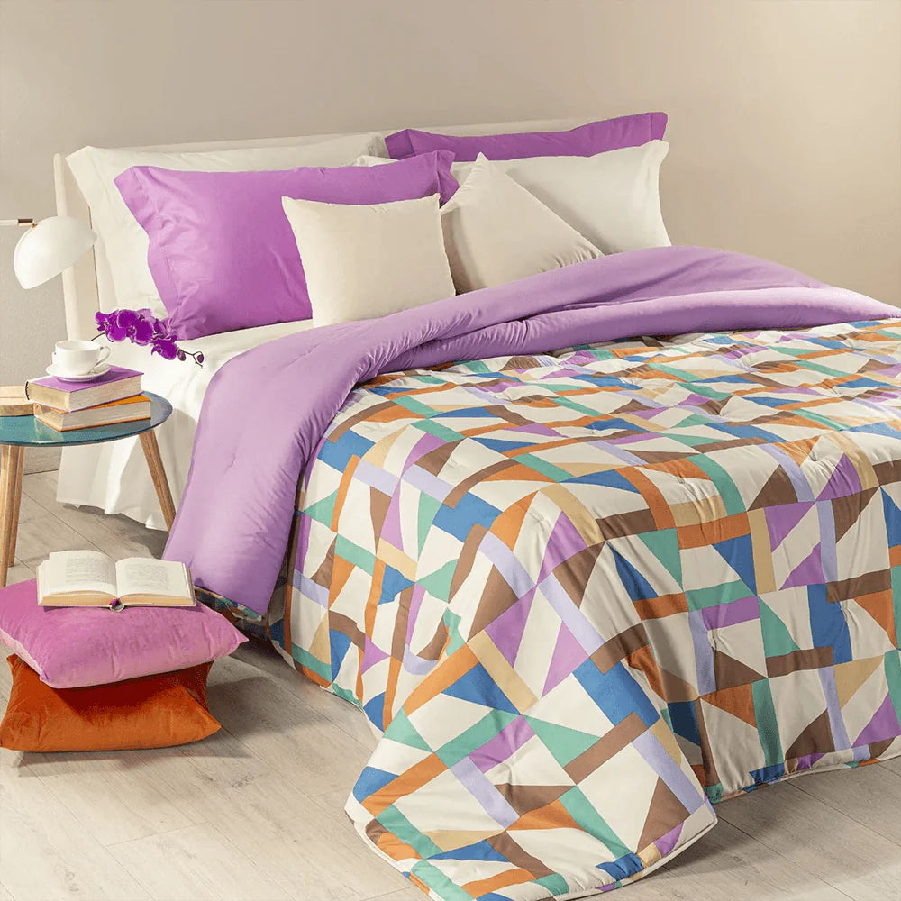 Trapunta invernale Caleffi Tuxedo in microfibra. Disponibile nella misura per letto singolo, piazza e mezza e matrimoniale. Fantasia allegra e moderna con forme geometriche colorate, variante multicolor con elementi rosa, arancioni e marroni, fondo panna.