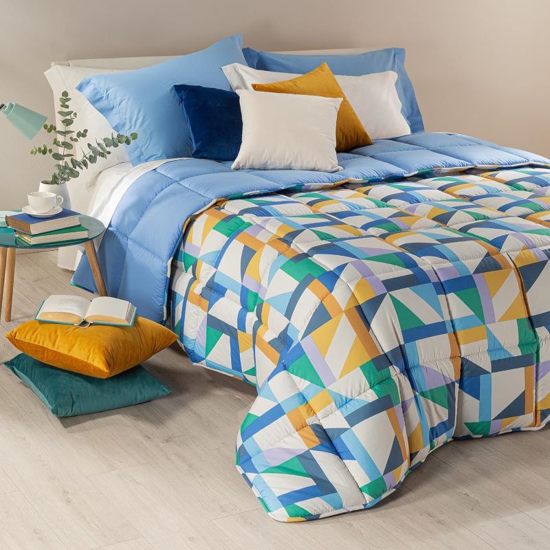 Trapunta invernale Caleffi Tuxedo in microfibra. Disponibile nella misura per letto singolo, piazza e mezza e matrimoniale. Fantasia allegra e moderna con forme geometriche colorate, variante bluette con elementi blu, verdi e senape.