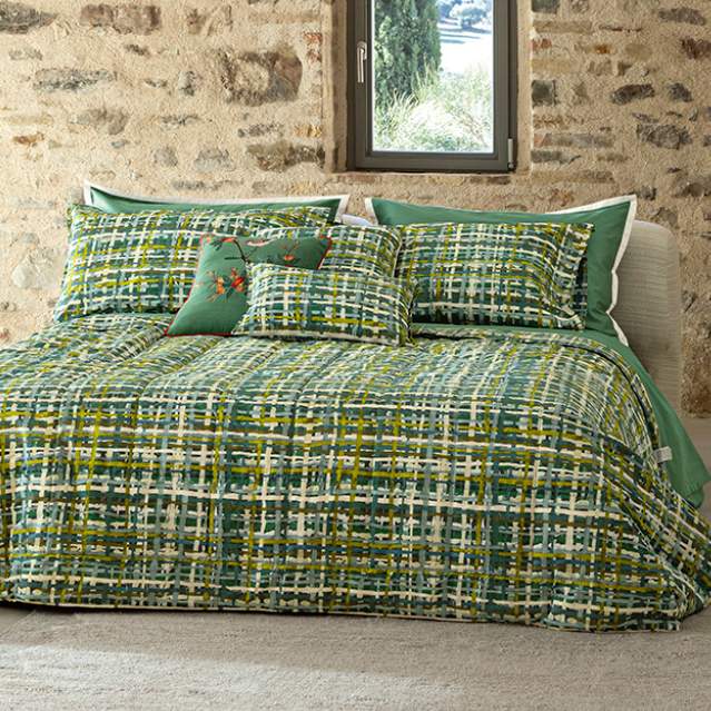 Trapunta invernale matrimoniale Fazzini Coco, in percalle di cotone.La fantasia della trapunta Coco trae spunto dalle lavorazioni tessili artigianali, i cui intrecci interpretano preziose creazioni senza tempo. Le fibre si incontrano in una griglia volutamente imperfetta, in cui qualche filo bianco è lasciato libero per regalare movimento alla superficie. Colore verde