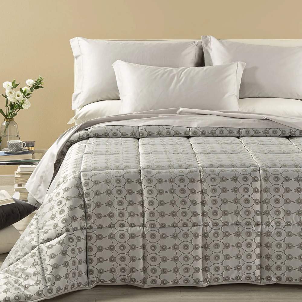 Trapunta invernale matrimoniale Caleffi Collins, in prezioso raso jacquard. La trapunta Collins è caratterizzata da una fantasia geometrica moderna dalle forme morbide. Colore grigio