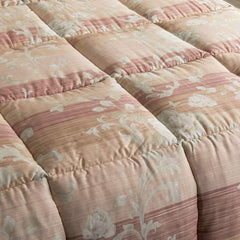 Trapunta invernale matrimoniale Caleffi Ermitage in raso di puro cotone. Variante corallo. Piumone con fantasia con fiori chiari su con fondo degradè sui toni caldi del rossiccio. dettaglio fantasia