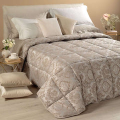 Trapunta invernale matrimoniale Caleffi Mida, in prezioso raso jacquard. Il piumone Mida presenta una fantasia dallo stile classico, nella variante di colore naturale tortora.