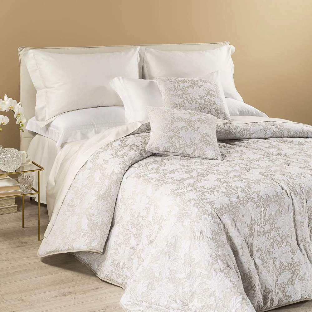 Trapunta invernale matrimoniale Leggerissima Vivienne, in prezioso raso jacquard. Prodotta da Caleffi. La trapunta Vivienne presenta una fantasia floreale dallo stile moderno, in cui tessuti diversi interagiscono dando vita a una fantasia su 3 livelli: il primo è rappresentato da fiori bianchi, il secondo da una delicata fantasia leopardata, mentre il terzo è dato dal tessuto di fondo più scuro e lucido rispetto ai primi due. Disponibile nella variante di colore avorio.
