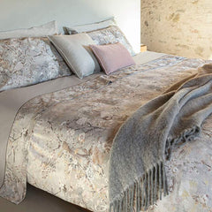 Trapunta invernale matrimoniale Fazzini Giardini d'Oriente, in raso di puro cotone. La collezione Giardini d'Oriente presenta una romantica fantasia floreale che ricorda i tessuti pregiati di fine Ottocento. Sul raso di cotone prendono vita rami in fiore e affascinanti uccelli dalle meravigliose piume. Colore grigio