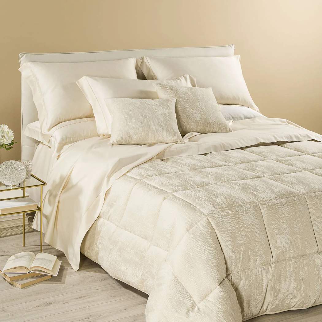 Trapunta invernale matrimoniale Caleffi Boheme, in prezioso raso jacquard. Piumone con fantasia tinta in filo tono su tono, con il tessuto della fantasia più chiaro e opaco che risalta sul fondo più lucido e scuro, dando un effetto striatura. Variante di colore avorio.