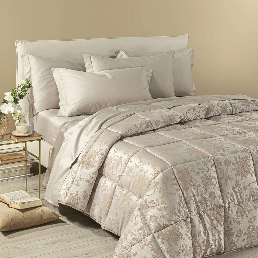 Trapunta invernale matrimoniale Caleffi Narciso, in prezioso raso jacquard. Il piumone Narciso è caratterizzato da una delicata fantasia floreale tono su tono. Colore ambra