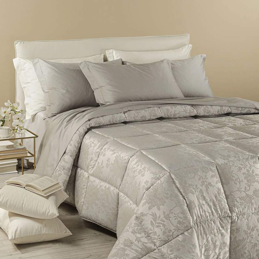 Trapunta invernale matrimoniale Caleffi Narciso, in prezioso raso jacquard. Il piumone Narciso è caratterizzato da una delicata fantasia floreale tono su tono. Colore sabbia tortora
