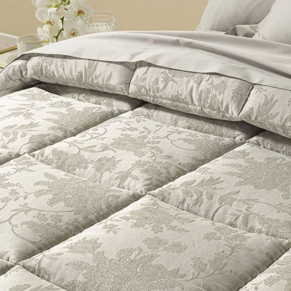 Trapunta invernale matrimoniale Caleffi Narciso, in prezioso raso jacquard. Il piumone Narciso è caratterizzato da una delicata fantasia floreale tono su tono. Colore sabbia tortora