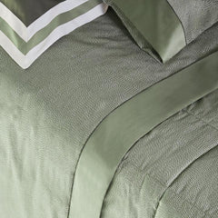 Trapunta invernale matrimoniale Fazzini Sashiko, in raso di puro cotone. La trapunta invernale Sashiko presenta una moderna fantasia a puntini, con una doppia sovrastampa che dona tridimensionalità e movimento alla microfantasia. Colore verde. Il piumone è trapuntato a capo e rifinito a mano con due angoli sagomati che lo adattano perfettamente agli angoli del letto