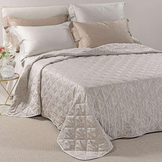 Trapuntino matrimoniale Caleffi Perleè, in elegante raso jacquard.La trapunta primaverile Perleè è caratterizzata da una fantasia geometrica moderna a puntini, colore tortora