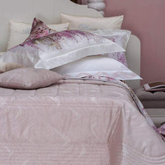 Trapuntino matrimoniale Crystelle di Blumarine, in elegante raso jacquard. Sinuosa fantasia jacquard dalle forme morbide, con inserti in lurex e logo Blumarine in cristalli. Disponibile nella variante di colore cipria rosa.