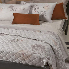 Trapuntino matrimoniale Crystal Borbonese, in raso di puro cotone stampato. Variante pesca. La trapunta primaverile Crystal è caratterizzata da una fantasia floreale dai toni delicati, con fiori color pesca e fondo beige con la tipica stampa Borbonese a occhio di pernice. Trapunta rifinita a mano con angoli stondati.