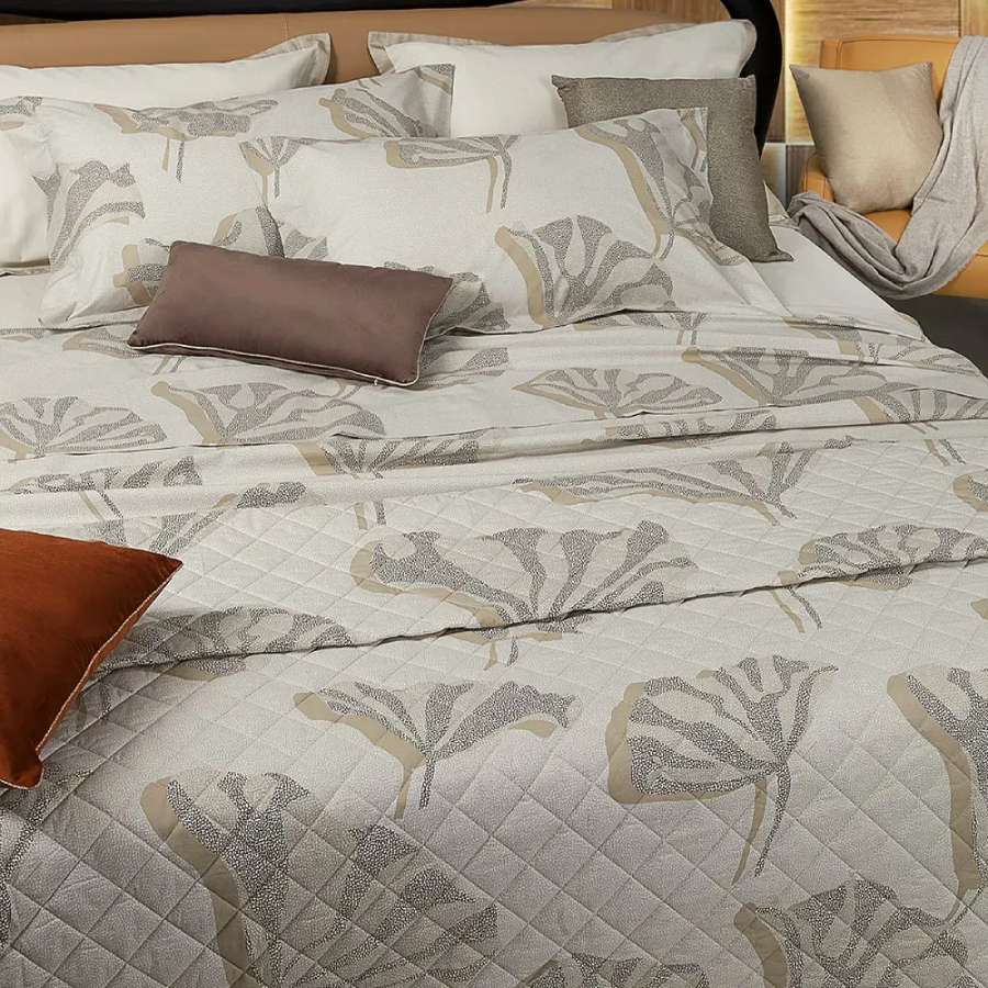 Trapuntino matrimoniale Decò Borbonese in percalle di puro cotone stampato.La trapunta primaverile Decò è caratterizzata da un fondo chiaro con la tipica stampa Borbonese a occhio di pernice, sulla quale risaltano delle foglie stilizzate in diverse colorazioni. Colore nocciola