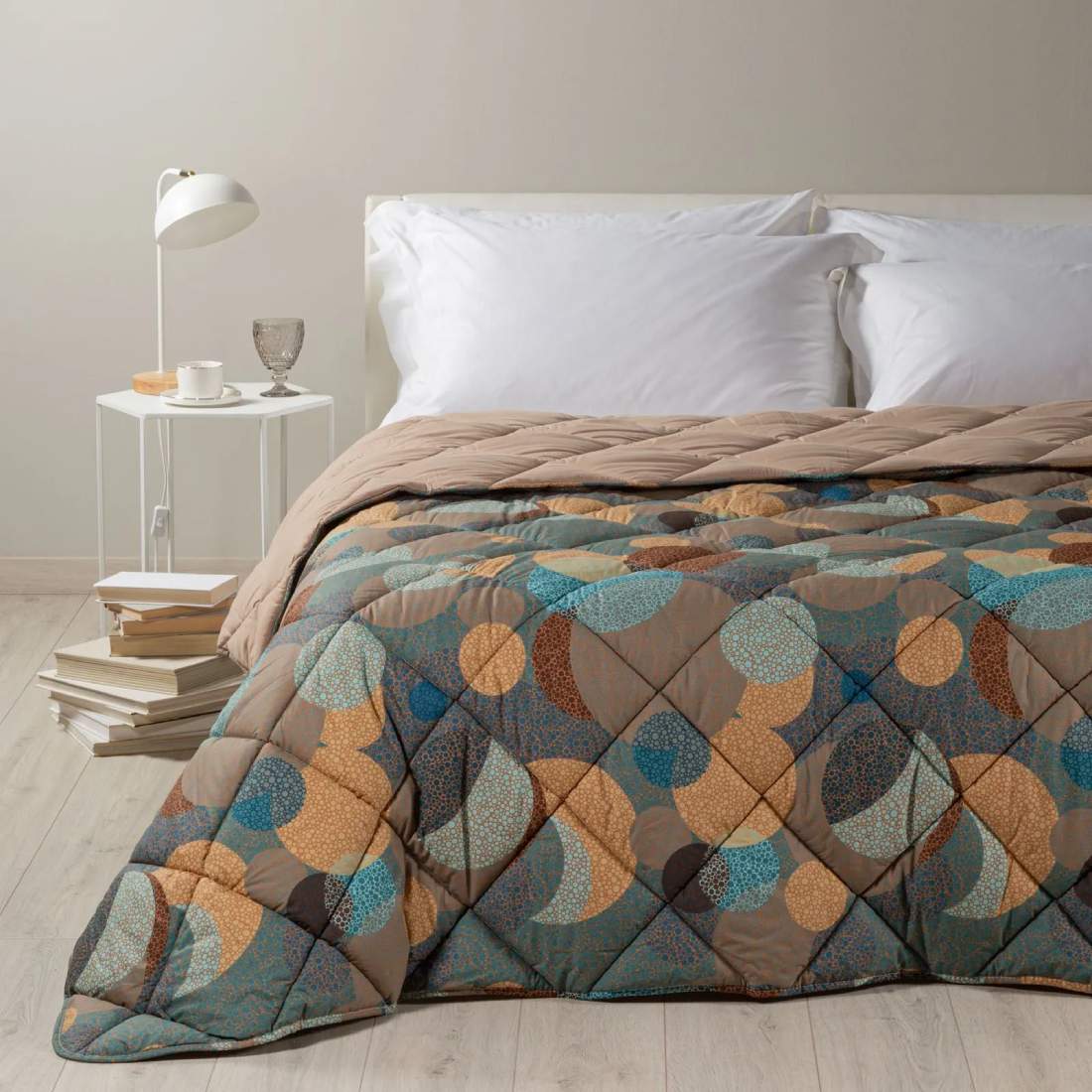 Trapunta primaverile matrimoniale Caleffi Cosmo. Fantasia geometrica multicolore dallo stile moderno, con forme che ricordano pianeti ed eclissi. Variante ambra