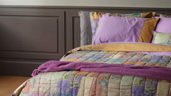 Trapunta primaverile matrimoniale Fazzini Crazy Quilt, in percalle di puro cotone. La collezione Crazy Quilt, col il suo spirito vagamente bohémienne, restituisce attraverso la stampa l'idea del patchwork, ma anche la matericità del lino e del rammendo che diventa ricamo. La trapuntatura del quilt valorizza l'effetto tridimensionale della fantasia. Il quilt è trapuntato a capo e rifinito a mano con due angoli sagomati che lo adattano perfettamente agli angoli del letto.