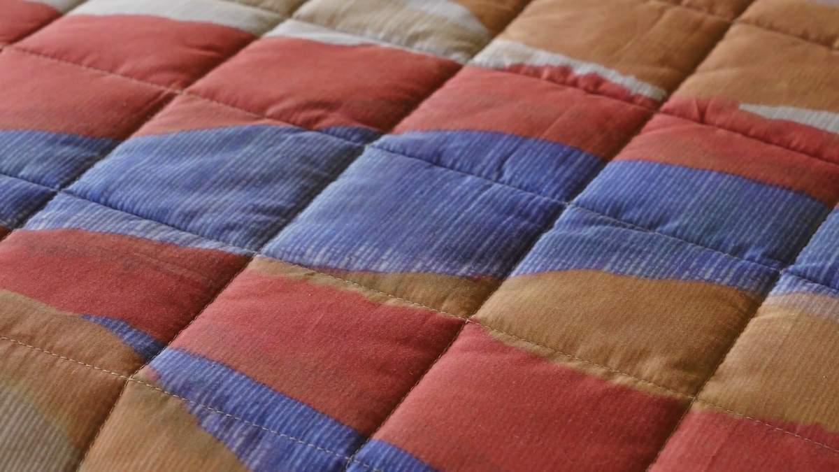 Trapunta primaverile matrimoniale Fazzini Arizona, in percalle di puro cotone. I colori delle terre si rincorrono nella collezione Arizona, dando origine a un affascinante paesaggio che richiama alla memoria le atmosfere del far west, con morbide dune colorate e cactus. Il quilt è trapuntato a capo e rifinito a mano con due angoli sagomati che lo adattano perfettamente agli angoli del letto. Trapunta primaverile