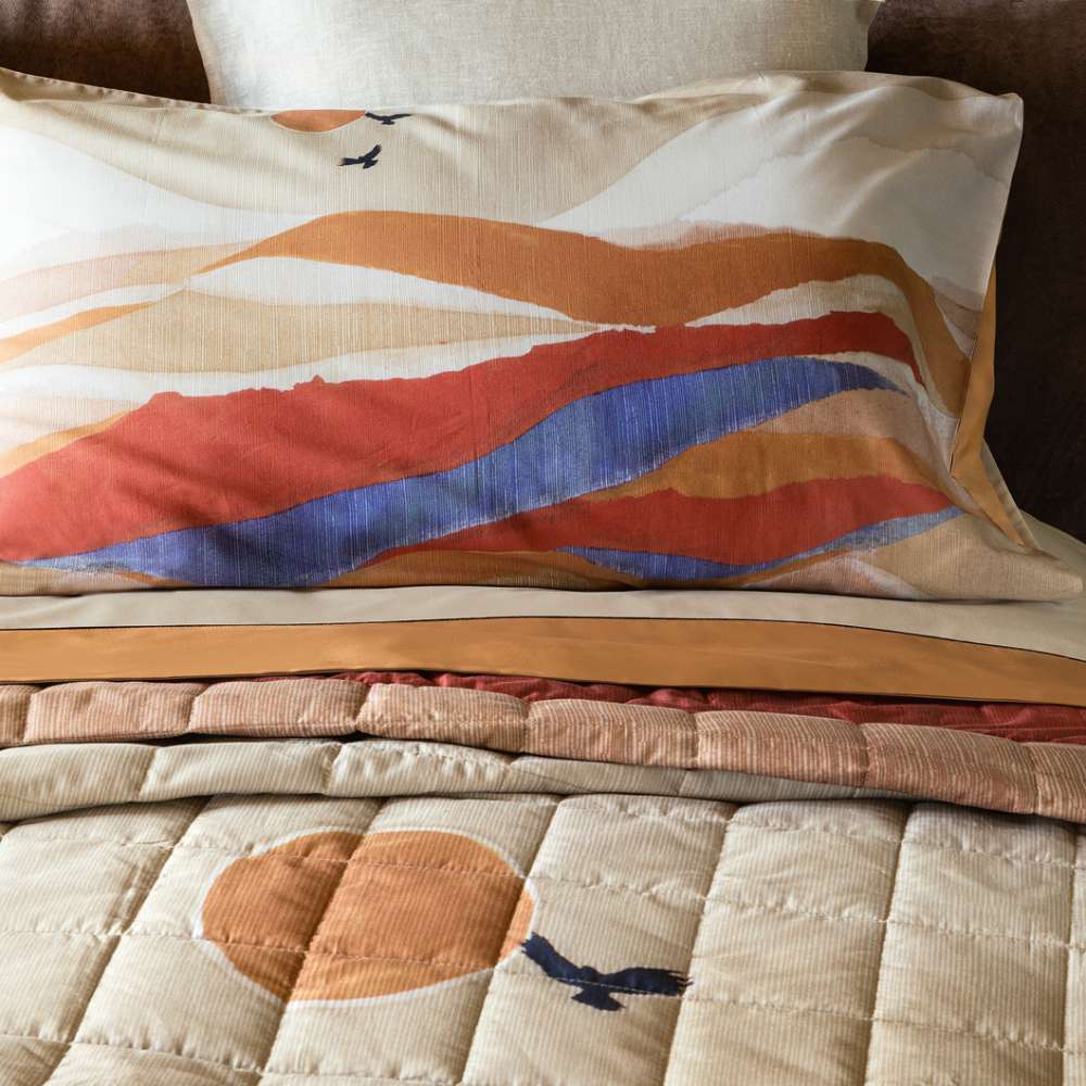 Trapunta primaverile matrimoniale Fazzini Arizona, in percalle di puro cotone. I colori delle terre si rincorrono nella collezione Arizona, dando origine a un affascinante paesaggio che richiama alla memoria le atmosfere del far west, con morbide dune colorate e cactus. Il quilt è trapuntato a capo e rifinito a mano con due angoli sagomati che lo adattano perfettamente agli angoli del letto. Trapunta primaverile