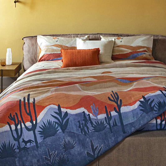 Trapunta primaverile matrimoniale Fazzini Arizona, in percalle di puro cotone. I colori delle terre si rincorrono nella collezione Arizona, dando origine a un affascinante paesaggio che richiama alla memoria le atmosfere del far west, con morbide dune colorate e cactus. Il quilt è trapuntato a capo e rifinito a mano con due angoli sagomati che lo adattano perfettamente agli angoli del letto. Trapunta primaverile