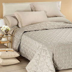 Trapuntino matrimoniale Caleffi Interiors in raso jacquard.La trapunta primaverile Interiors presenta una fantasia moderna ma delicata, con foglie che si intersecano in una fitta trama. Copriletto trapuntato colore bosco tortora.