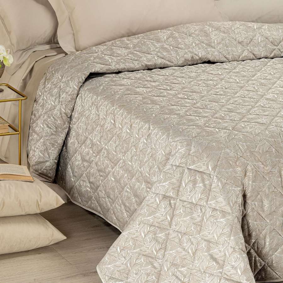 Trapuntino matrimoniale Caleffi Interiors in raso jacquard.La trapunta primaverile Interiors presenta una fantasia moderna ma delicata, con foglie che si intersecano in una fitta trama. Copriletto trapuntato colore bosco tortora.