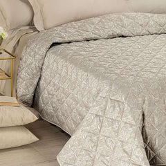 Trapuntino matrimoniale Caleffi Interiors in raso jacquard.La trapunta primaverile Interiors presenta una fantasia moderna ma delicata, con foglie che si intersecano in una fitta trama. Copriletto trapuntato colore bosco tortora.