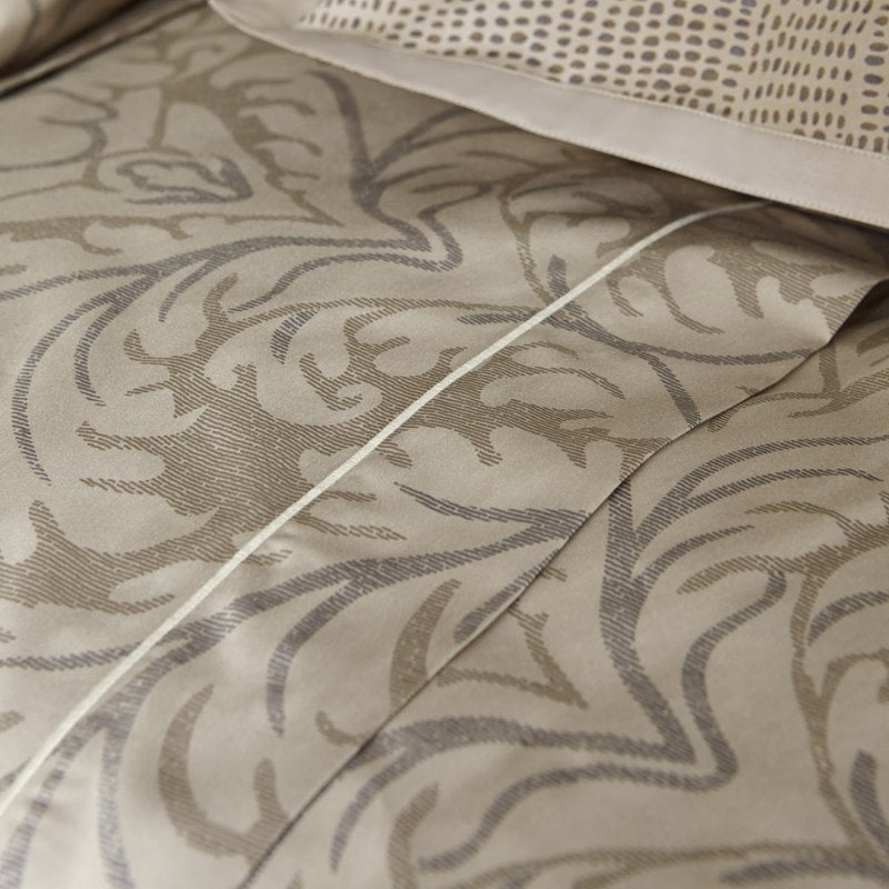 Trapuntino matrimoniale Novecento, della linea Fazzini Atelier, in prezioso raso di puro cotone. La fantasia del quilt Novecento è ispirata ai tessuti damasco. Il disegno nelle tonalità del grigio e del beige è caratterizzato da una stampa vibrante che alterna superfici perlescenti e dettagli calcati. Trapunta primaverile colore torrone tortora. Dettaglio fantasia