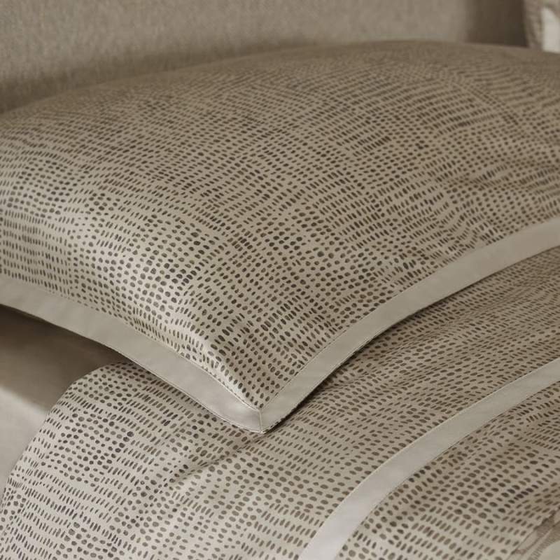 Trapuntino matrimoniale Pirellone, della linea Fazzini Atelier, in raso di puro cotone. La fantasia minimal dall'effetto traslucido del quilt Pirellone rivela una texture chiaramente contemporanea, che nella camera da letto diventa importante elemento di arredo. La trapunta primaverile Pirellone è trapuntata a capo e rifinita a mano con due angoli sagomati che la adattano perfettamente agli angoli del letto