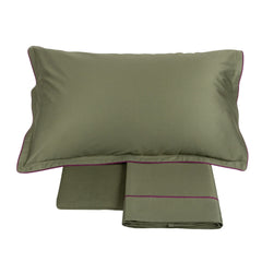 Completo lenzuola matrimoniale Fazzini Deal, in raso di puro cotone tinta unita. Colore di fondo verde cactus, bordi viola prugna