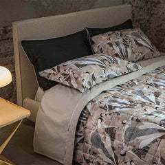 Completo lenzuola e trapunta matrimoniale Fazzini Splash in percalle di puro cotone. Fantasia in cui figure femminili danno vita a una danza in cui si mescolano elementi grafici e dettagli acquerellati.. Colore rosa e grigio.