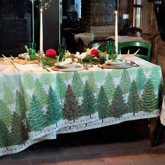 Tovaglia natalizia Fairy Trees in puro lino di Tessitura Toscana Telerie. Fantasia su fondo chiaro, con abeti verdi addobbati per il Natale. Misura rettangolare x12 (170x270 cm).