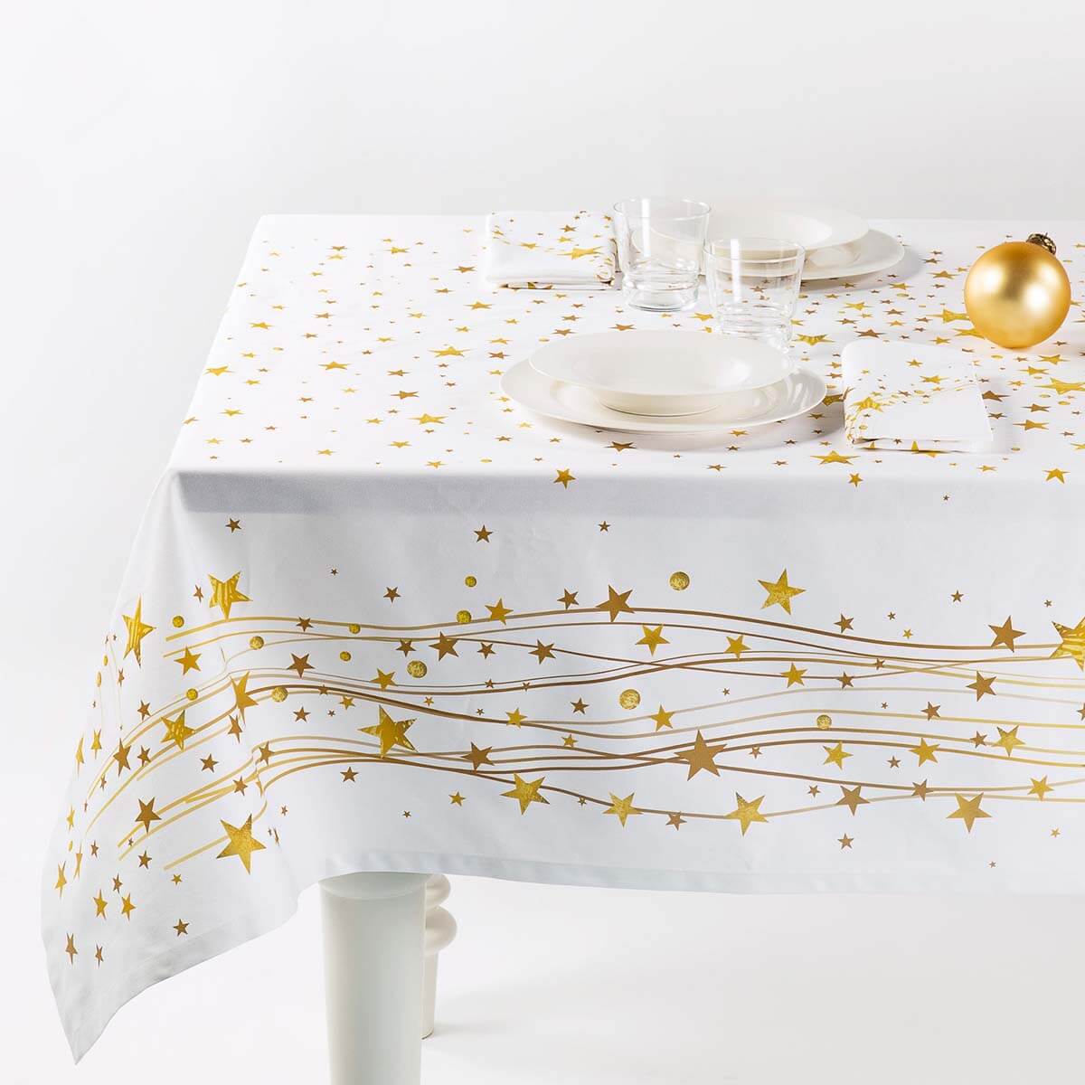Tovaglia natalizia Gold di Caleffi. Stampa digitale su panama di puro cotone. Fantasia su fondo bianco con stelle, righe e sfere dorate che richiamano l'atmosfera del Natale. Tovaglia rettangolare per 12 persone.