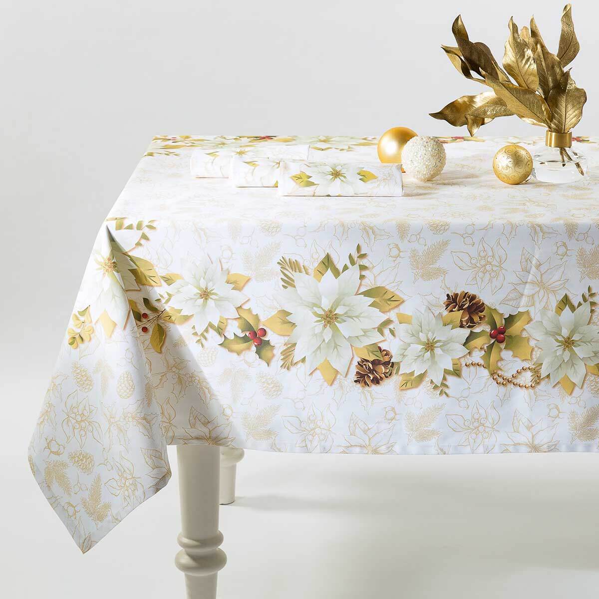 Tovaglia natalizia Stella Bianca di Caleffi. Stampa digitale su panama di puro cotone. Fantasia su fondo bianco con pigne e fiori dorati che richiamano l'atmosfera del Natale. Misura rettangolare x12 (150x280 cm).