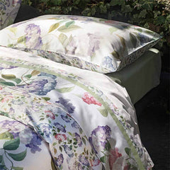 Trapunta invernale piumone matrimoniale Ortensie Fazzini in percalle di puro cotone. Fantasia floreale con fiori rosa e glicine. Collezione autunno inverno 2021. Dettaglio con lenzuolo.