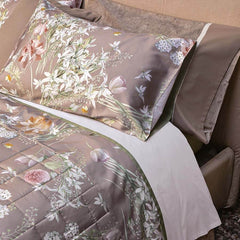 Completo lenzuola matrimoniale Fazzini Lilia in percalle e raso di puro cotone. Lenzuolo con fantasia floreale su fondo tortora/sasso. Fiori bianchi e colorati.
