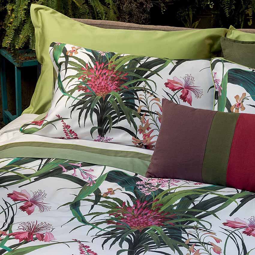 Completo Lenzuola matrimoniale Fazzini Hibiscus in raso e percalle di cotone. Fantasia floreale con fiori rosa sulle federe in raso di cotone. Lenzuolo di sotto in percalle tinta unita verde. Collezione primavera estate 2021.
