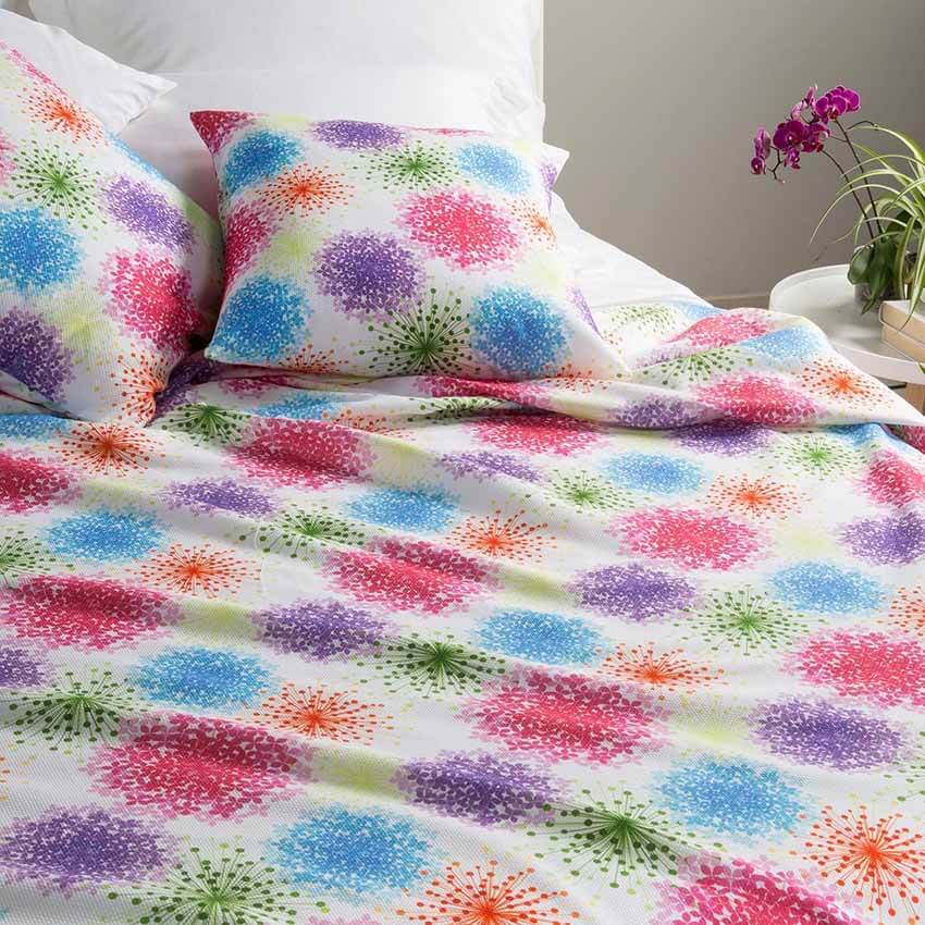 Coperta estiva Caleffi Bloom, in piquet di puro cotone con stampa digitale. Fantasia allegra e vivace con fiori colorati su fondo chiaro.