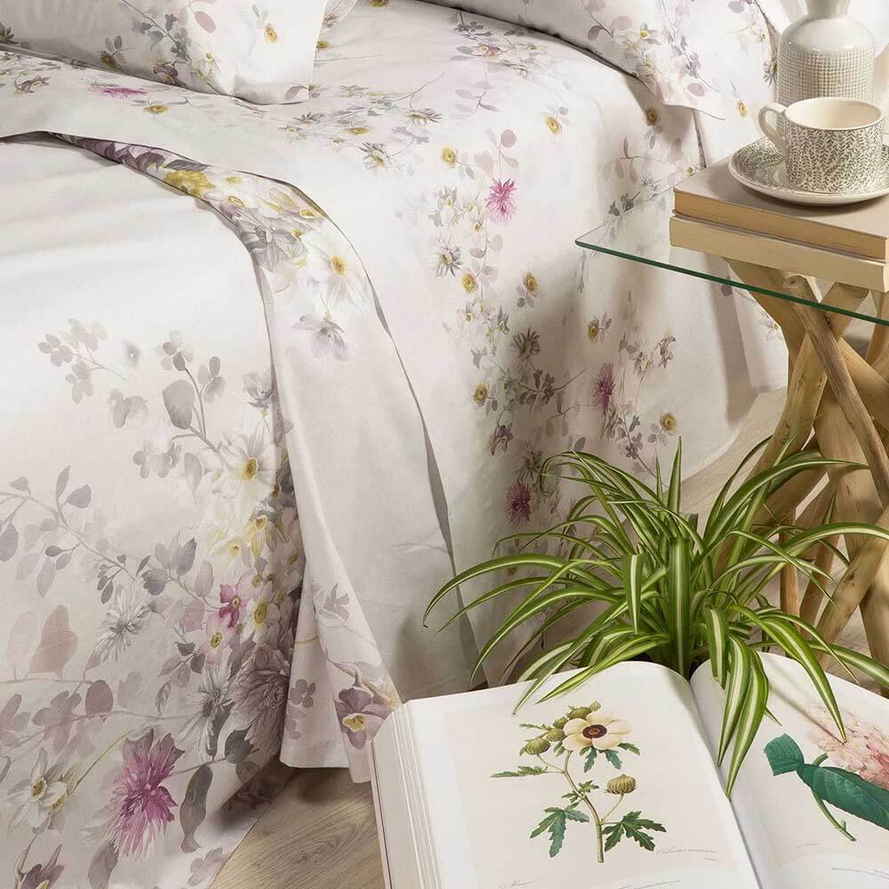 Coperta estiva Caleffi Aurora, in panama di puro cotone con stampa digitale. Fantasia con fiori delicati su fondo beige/tortora. Copriletto estivo per letto matrimoniale. Dettaglio coperta e lenzuolo