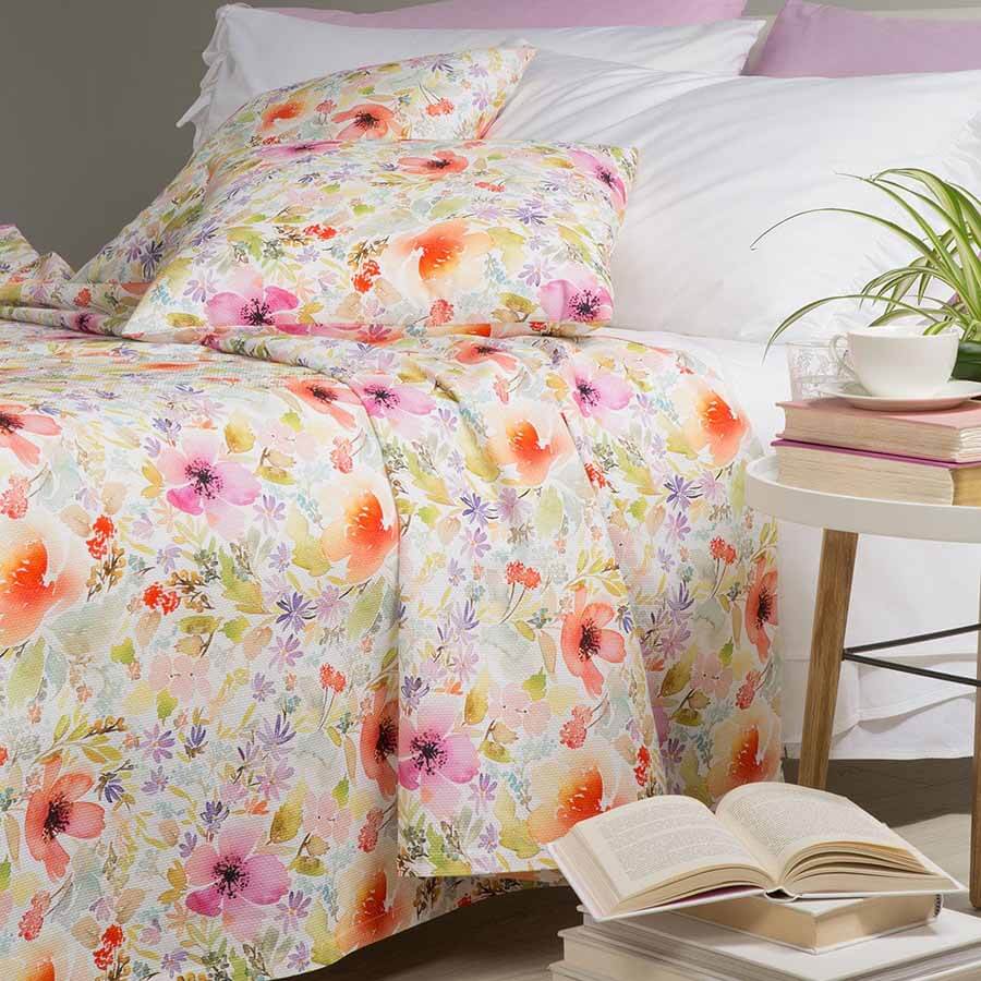 Coperta estiva Caleffi Isola dei Fiori, in piquet di puro cotone con stampa digitale. Fantasia allegra e vivace con fiori colorati su fondo chiaro. Disponibile per letto singolo, piazza e mezza e matrimoniale.